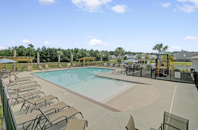 community pool with a patio, a pergola, and fence