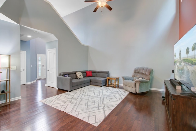 living room featuring dark wood finished floors, high vaulted ceiling, baseboards, and a ceiling fan