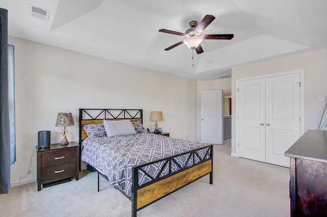 bedroom featuring visible vents, ceiling fan, a closet, and light colored carpet