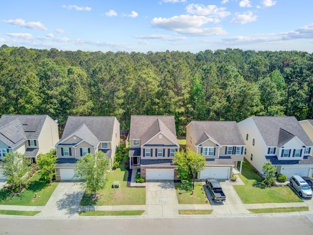 bird's eye view featuring a wooded view and a residential view