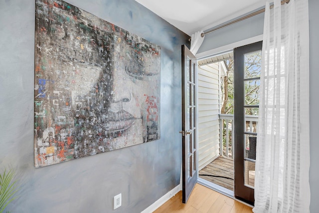 doorway to outside with wood finished floors and baseboards