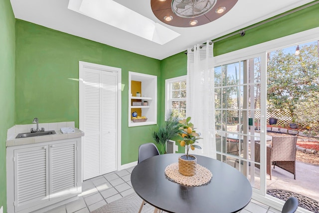 tiled dining area with built in features, plenty of natural light, and a sink