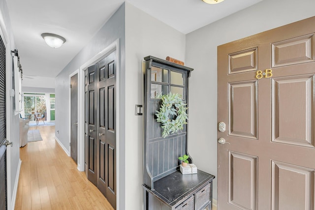 foyer featuring baseboards and light wood-type flooring