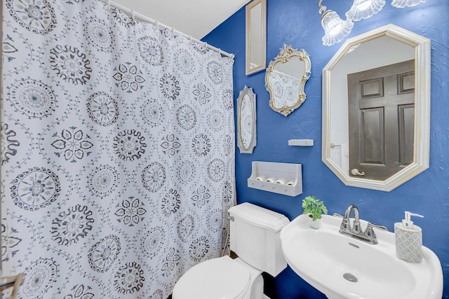 bathroom with a sink, a shower with curtain, and toilet