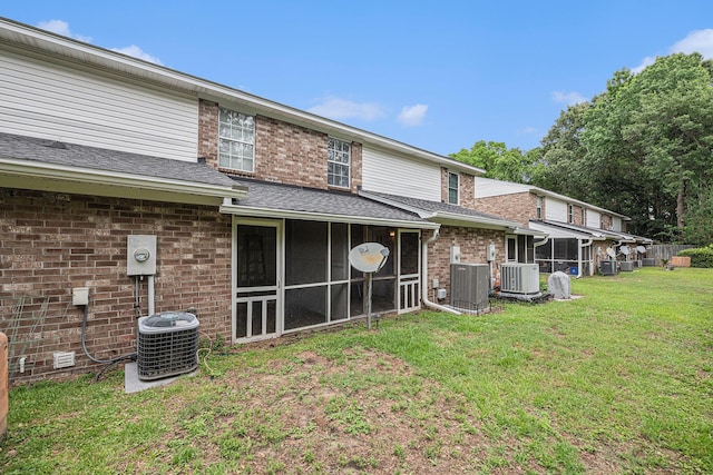 2045 Rondo St Unit B, Charleston, SC 29414 - rear view of house featuring a sunroom, central AC unit, roof with shingles, and a lawn
