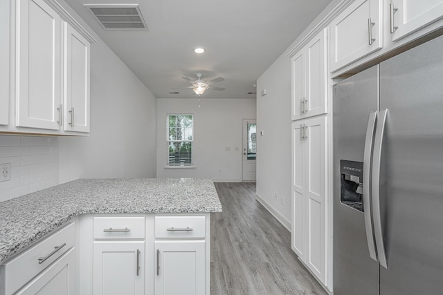 kitchen featuring white cabinets, visible vents, backsplash, and stainless steel fridge with ice dispenser