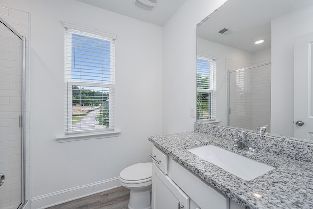 bathroom with toilet, wood finished floors, visible vents, baseboards, and a shower stall