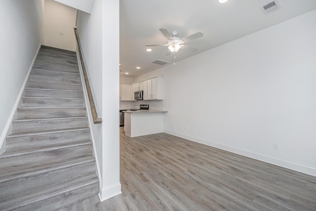 staircase with recessed lighting, visible vents, ceiling fan, and wood finished floors