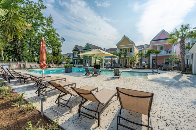 community pool with a patio and fence