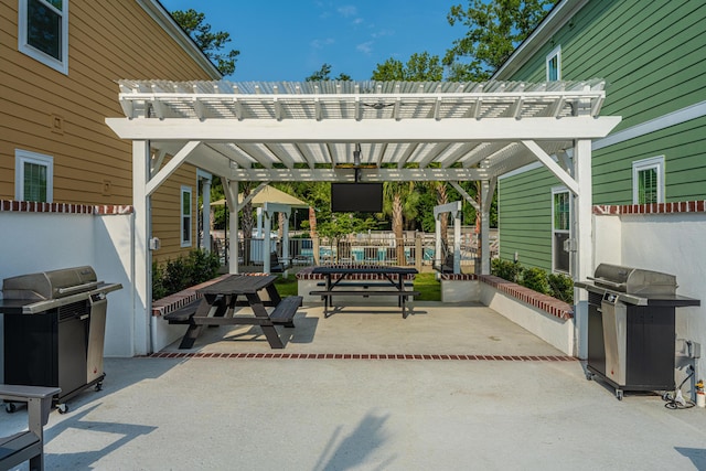 view of patio featuring area for grilling, fence, and a pergola