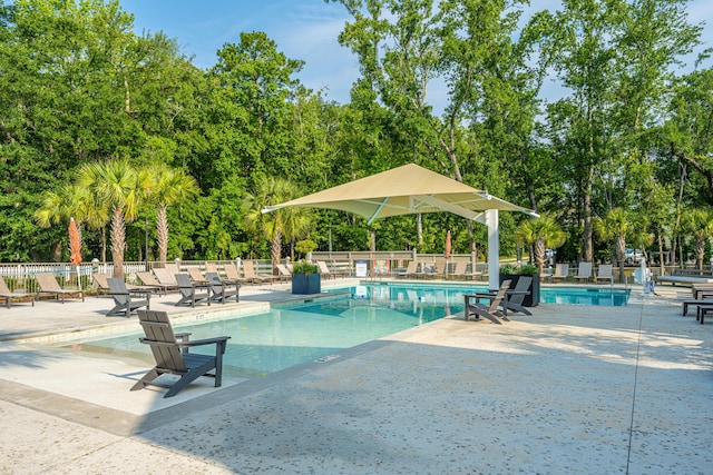 community pool with a patio area and fence