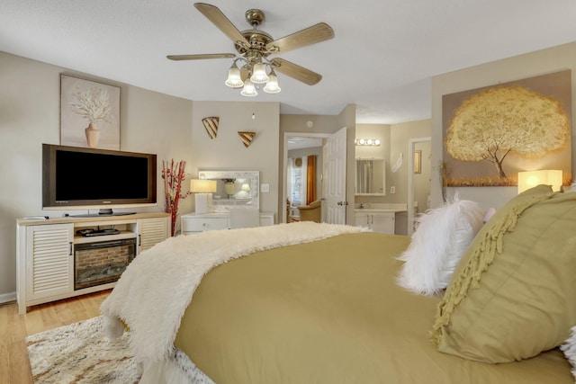 bedroom featuring light hardwood / wood-style floors, connected bathroom, and ceiling fan