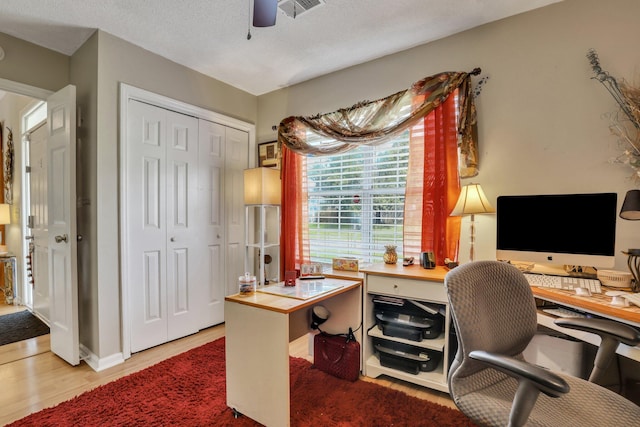 home office with a textured ceiling, wood-type flooring, and ceiling fan