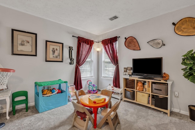 rec room with light carpet and a textured ceiling