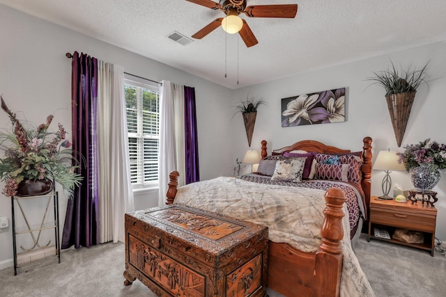 carpeted bedroom with ceiling fan and a textured ceiling