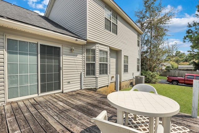 wooden deck with a lawn and cooling unit