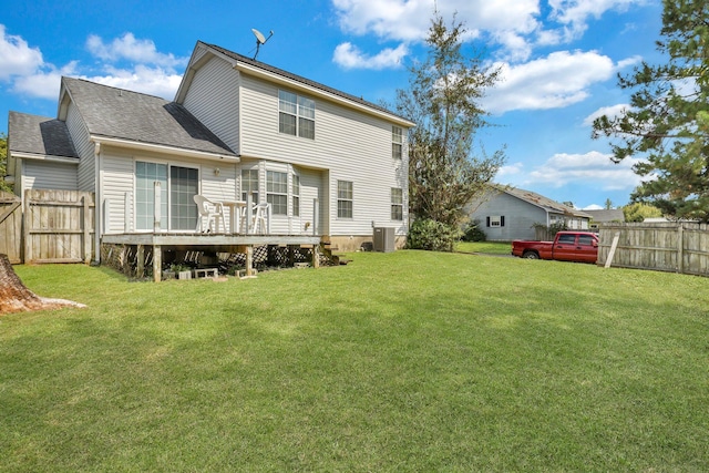 rear view of house with central AC, a deck, and a yard