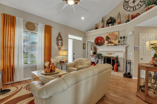 living room featuring ceiling fan, light hardwood / wood-style flooring, and high vaulted ceiling