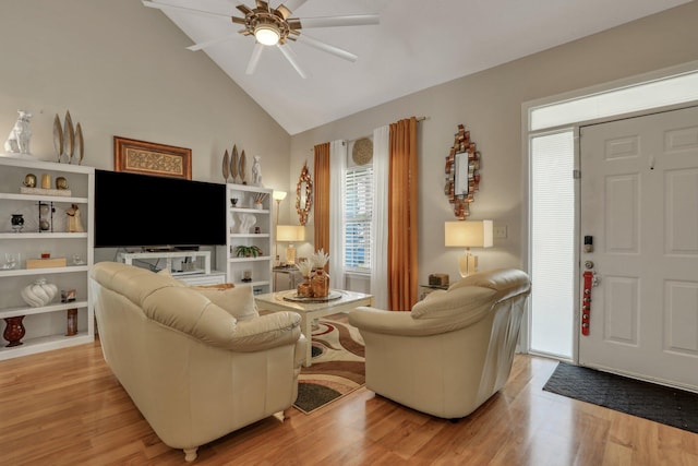 living room with ceiling fan, light hardwood / wood-style flooring, and vaulted ceiling