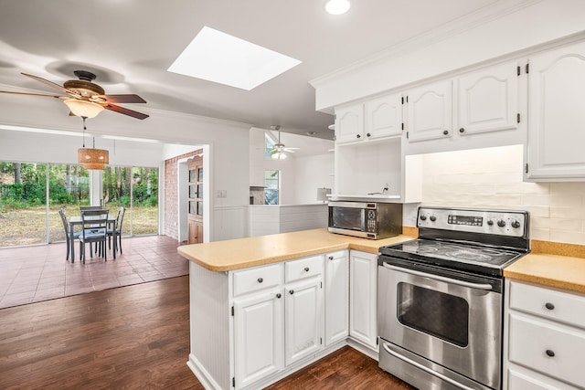 kitchen featuring appliances with stainless steel finishes, a peninsula, light countertops, crown molding, and backsplash