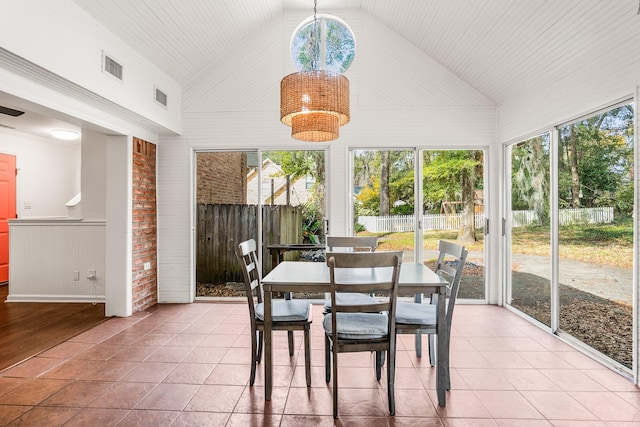 sunroom / solarium featuring lofted ceiling, visible vents, and an inviting chandelier