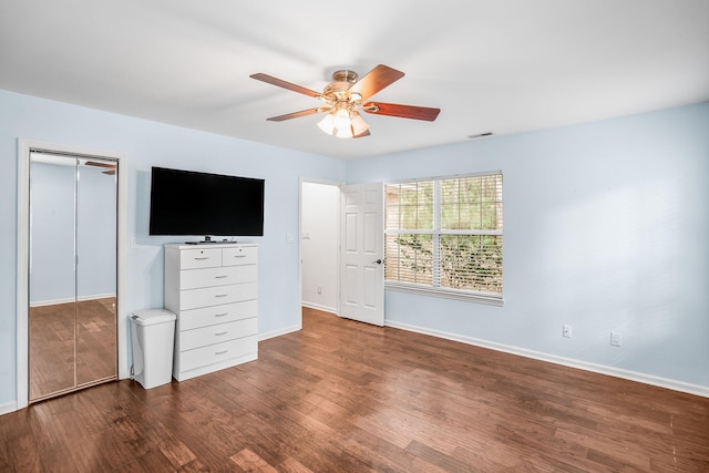 unfurnished bedroom with ceiling fan, wood finished floors, visible vents, baseboards, and a closet