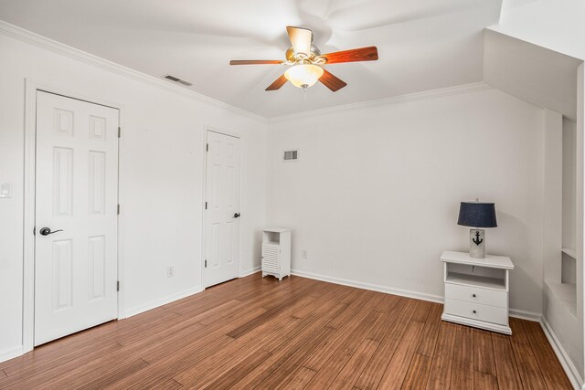 unfurnished bedroom featuring ornamental molding, visible vents, and wood finished floors