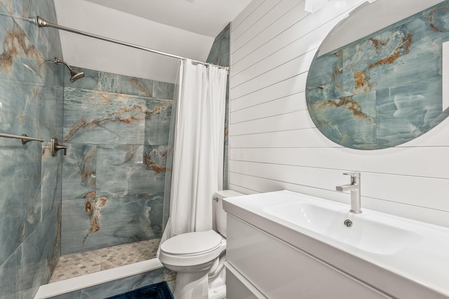 bathroom featuring tiled shower, wood walls, vanity, and toilet