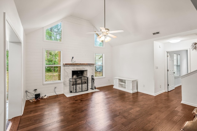 living room with visible vents, baseboards, wood-type flooring, a premium fireplace, and ceiling fan