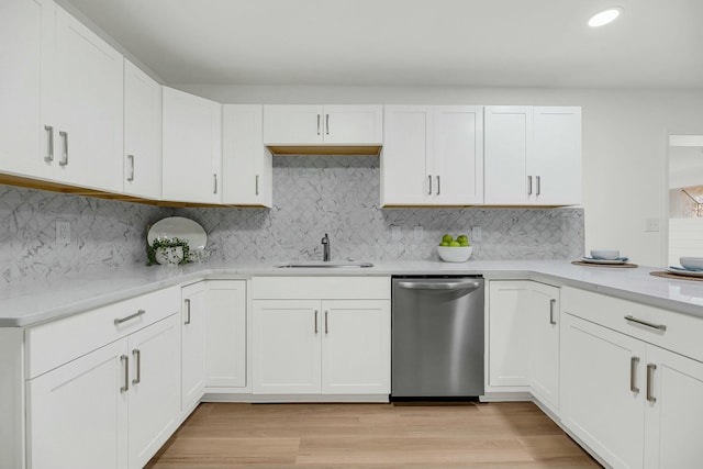 kitchen featuring dishwasher, light hardwood / wood-style floors, white cabinetry, and sink