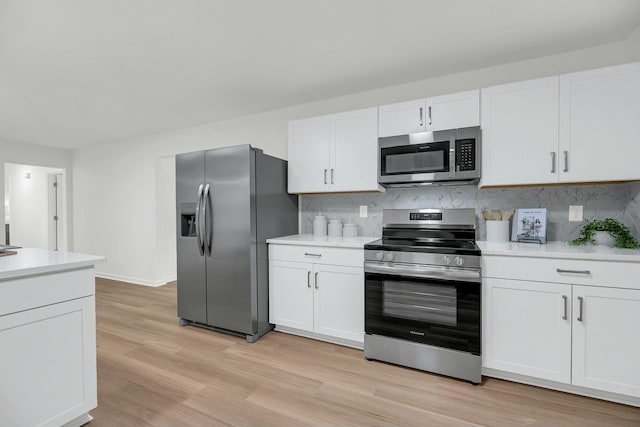 kitchen with white cabinets, backsplash, light hardwood / wood-style floors, and stainless steel appliances