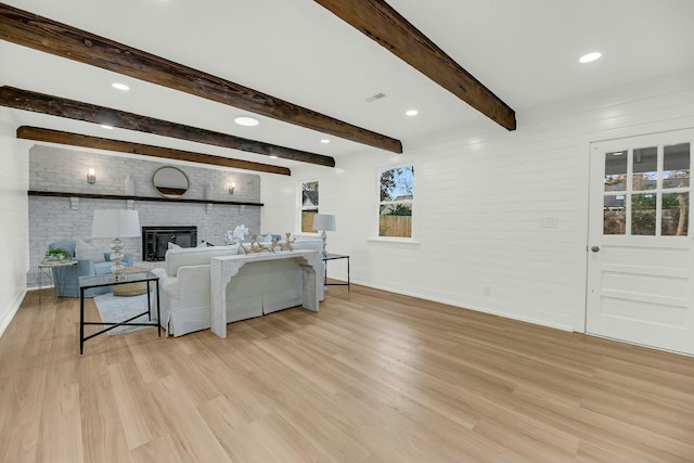 living room featuring beamed ceiling and light wood-type flooring