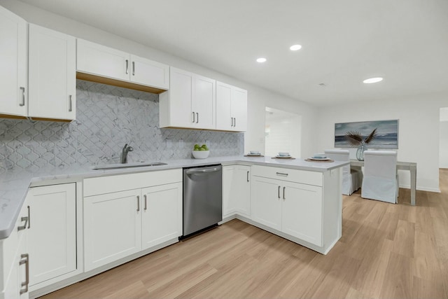 kitchen featuring dishwasher, white cabinetry, sink, and light hardwood / wood-style flooring