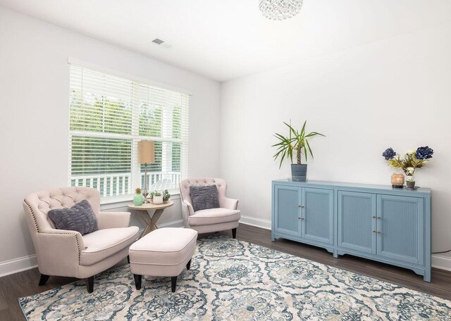 living area featuring baseboards, dark wood finished floors, and visible vents