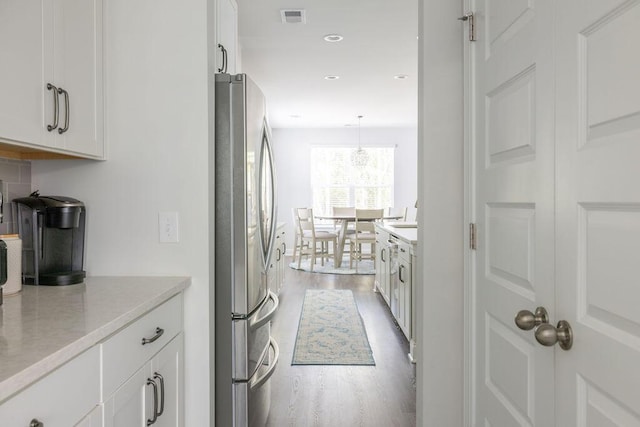 kitchen featuring visible vents, freestanding refrigerator, white cabinetry, recessed lighting, and light wood finished floors