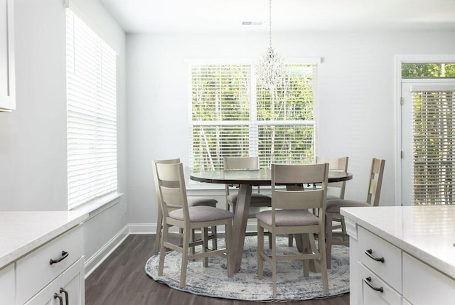 dining room with dark wood-type flooring, baseboards, and an inviting chandelier