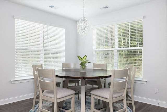 dining area with dark wood-type flooring, visible vents, and baseboards