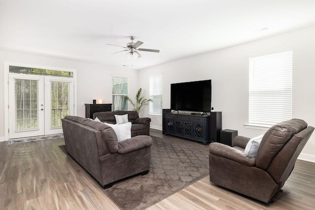 living area featuring french doors, wood finished floors, ceiling fan, and baseboards