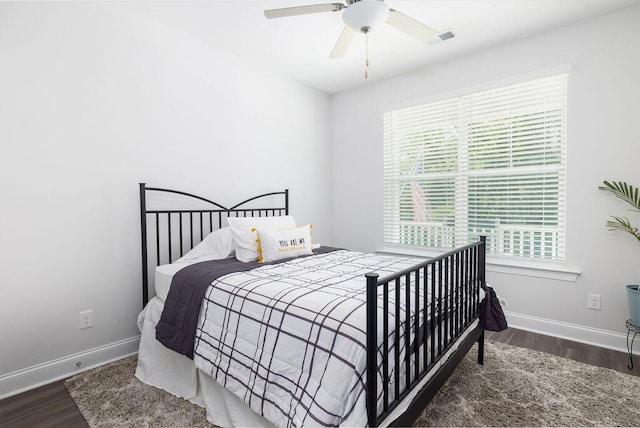 bedroom with visible vents, baseboards, a ceiling fan, and wood finished floors