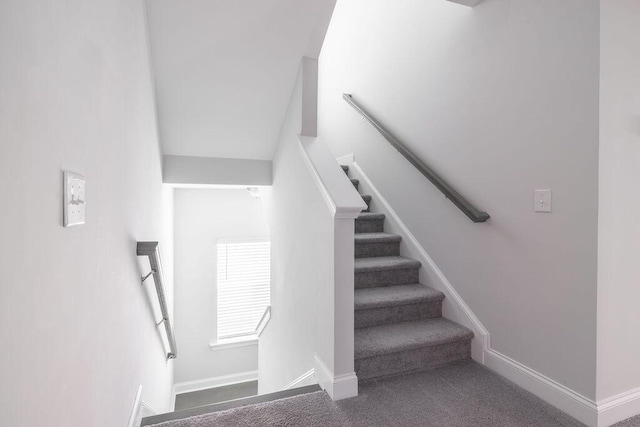 stairway with baseboards and carpet flooring