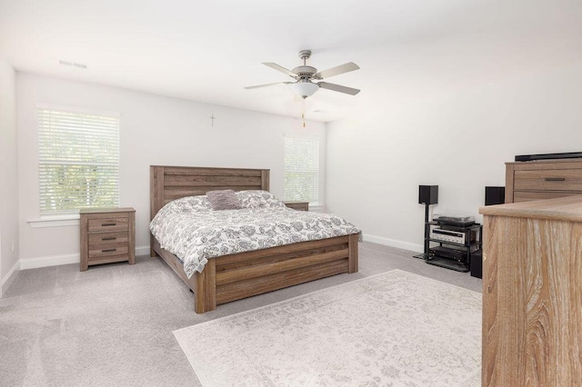 bedroom with carpet flooring, visible vents, multiple windows, and baseboards