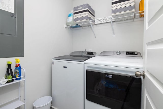 washroom featuring electric panel, separate washer and dryer, and laundry area