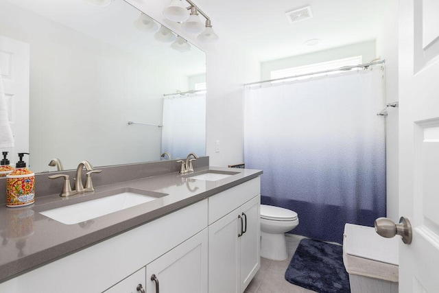 full bathroom featuring a sink, visible vents, toilet, and double vanity