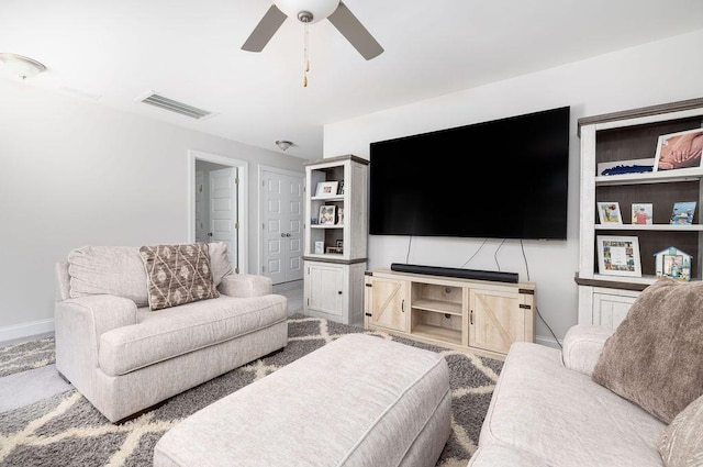 carpeted living area featuring ceiling fan, baseboards, and visible vents