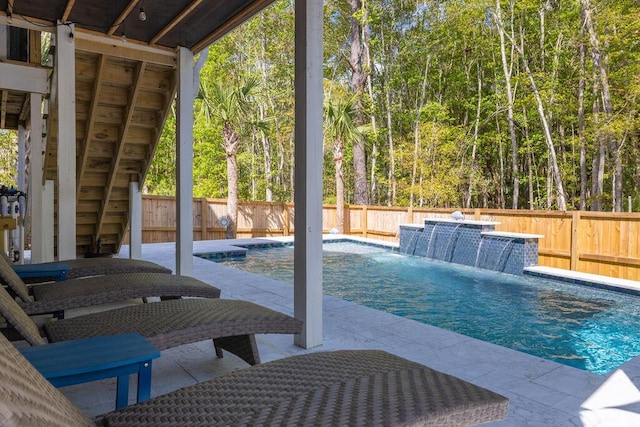 view of pool with a patio area, a fenced backyard, a view of trees, and a fenced in pool