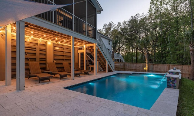 view of swimming pool with a patio area, a fenced in pool, fence, and stairway