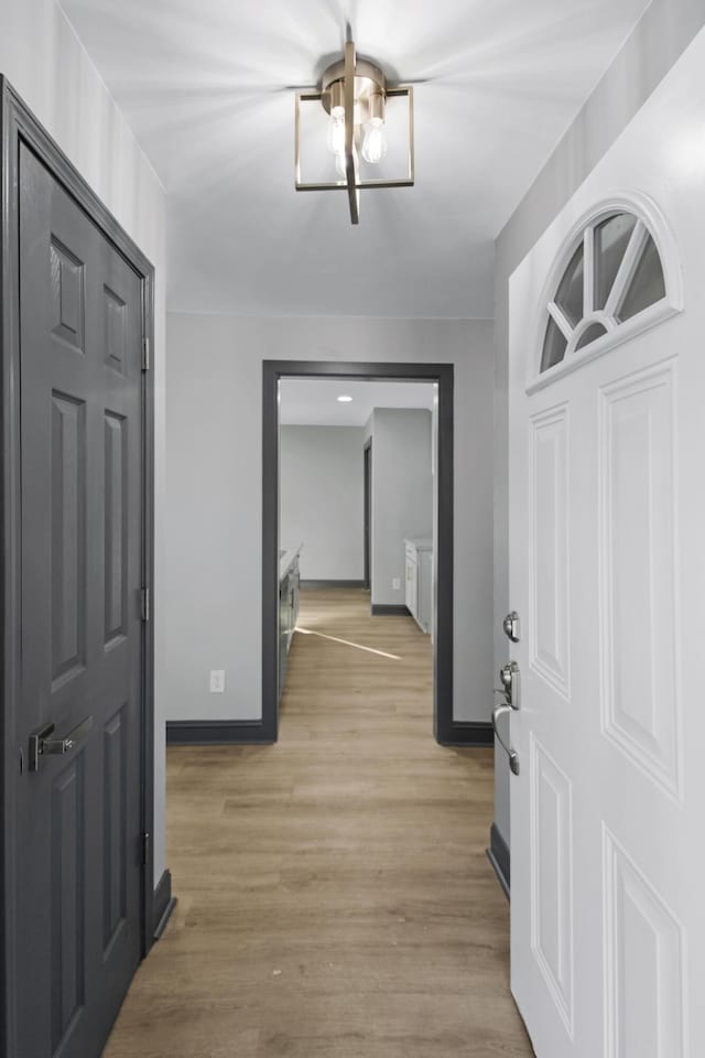 hall featuring a chandelier and light wood-type flooring