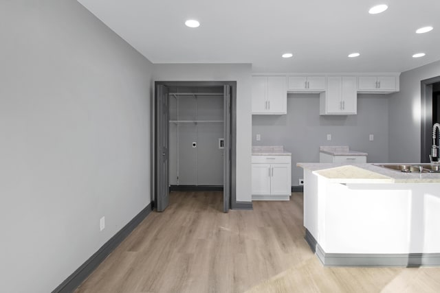 kitchen featuring white cabinetry, sink, and light hardwood / wood-style floors