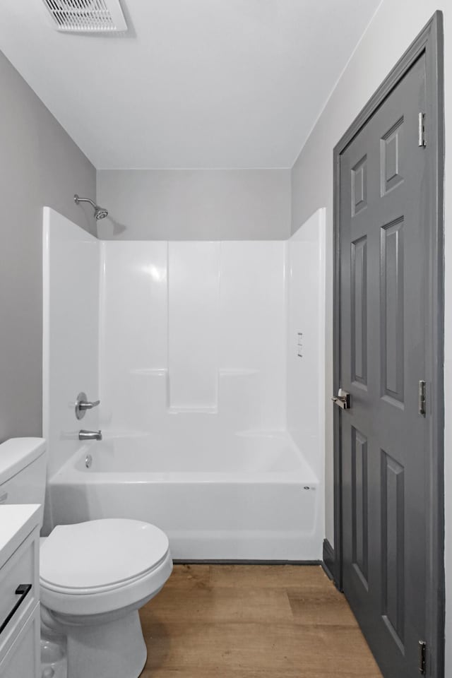 full bathroom featuring shower / bath combination, wood-type flooring, vanity, and toilet