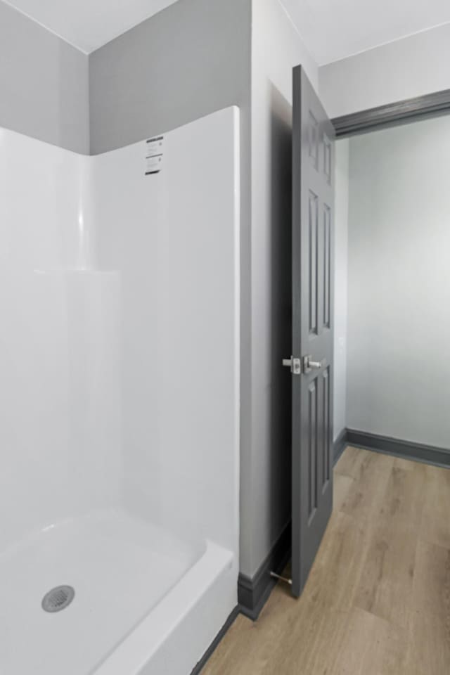 bathroom featuring hardwood / wood-style floors and walk in shower